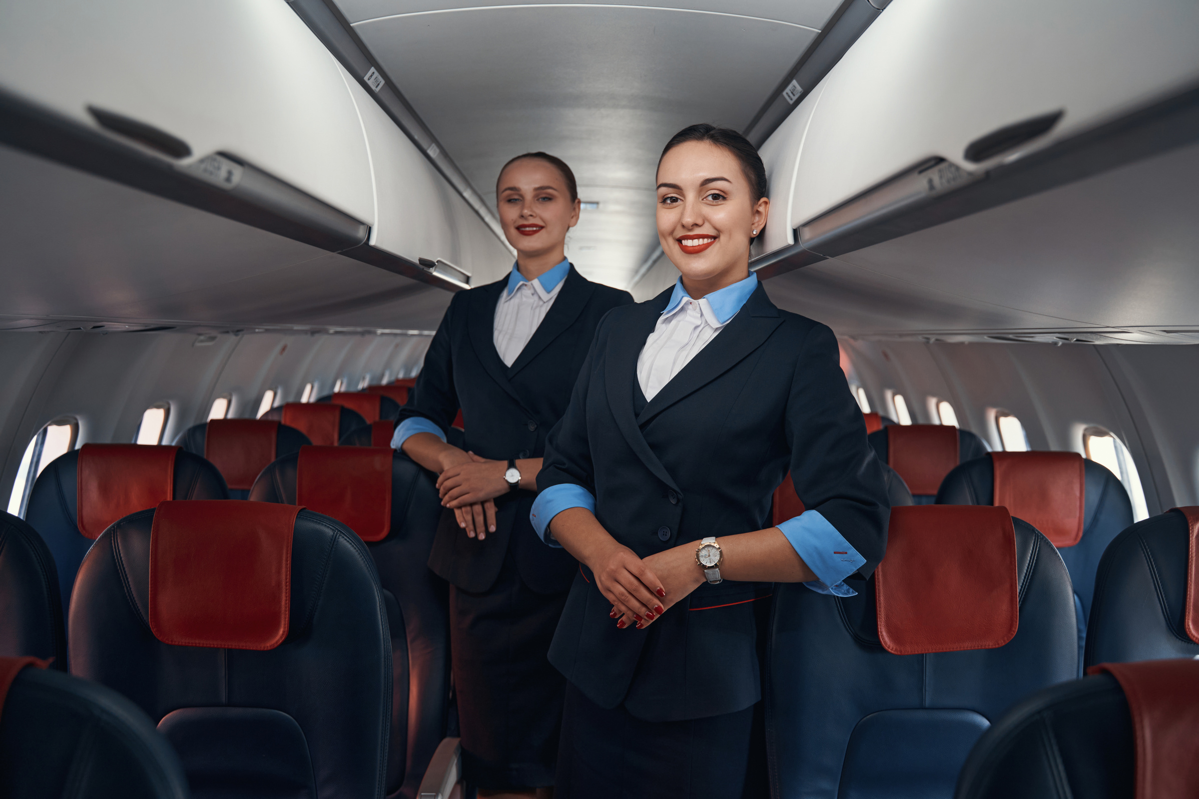 Cabin crew members posing for photo inside plane